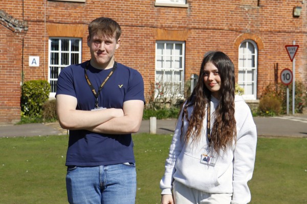 A Level students Corey and Millie in front of the entrance to Paston College