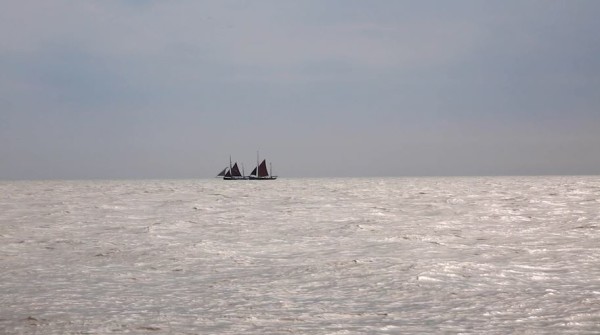 Two smack boats on the horizon off the Norfolk coast.